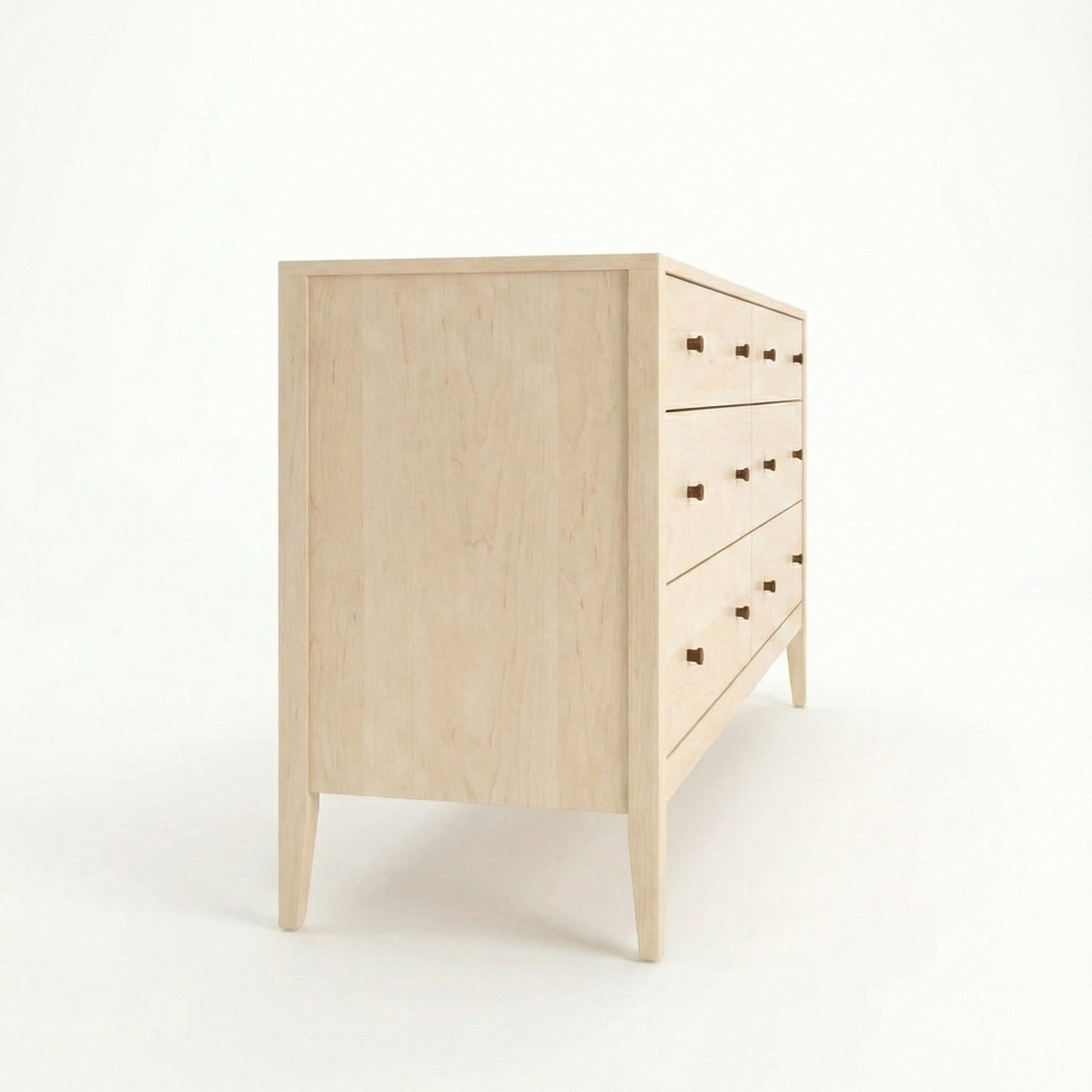 side view of a solid wood hard maple vermont made dresser with black knobs. shown in a vermont woods studio