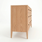 side view of an elegant six drawer dresser in red oak wood with refined black knobs. This piece is complete with under-mounted drawer slides and english dovetail joints.