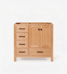 A light natural Cherry bathroom vanity cabinet with Five drawers, two doors with round black knobs, and a top-mounted sink basin, shown on a white background.